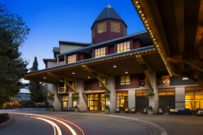 The lit front entrance of Delta Hotels Whistler Village Suites at dusk